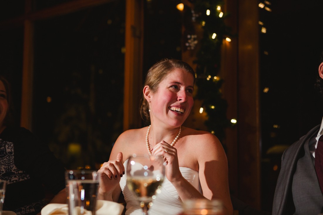 bride crying in reception while listening to a video clip made by her brother