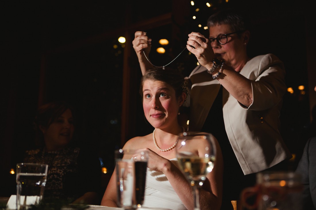 bride's mother giving her a necklace as wedding gift and she is putting the necklace on the bride's neck