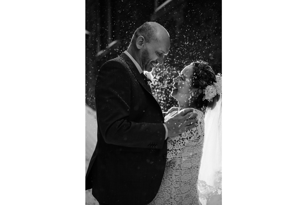 bride and groom having a fun moment with snow splashing after the ceremony under snow in an alley of old port, montreal